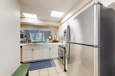 a large kitchen with a stainless steel refrigerator at Beachfront condo with 2 beach chairs included & pickleball - short walk to dining in Seacrest