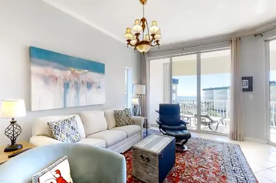 a living room with a couch and a chair at Magical 3rd-floor condo with pools telescope for stargazing & pickleball in Santa Rosa Beach