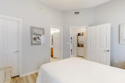 a white bedroom with a bed and white walls at Magical 3rd-floor condo with pools telescope for stargazing & pickleball in Santa Rosa Beach