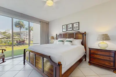 a bedroom with a large bed and a large window at Coastal condo with lagoon pool bike rentals tennis pickleball & beach access in Seacrest