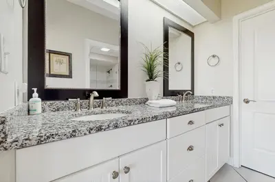 a white bathroom with a sink and a mirror at Coastal condo with lagoon pool bike rentals tennis pickleball & beach access in Seacrest