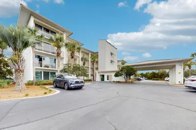 a car parked in a parking lot in front of a building at Snowbird-friendly condo with pickleball on the beach close to shops & dining in Seacrest
