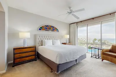 a bedroom with a bed and a couch and a window at Snowbird-friendly condo with pickleball on the beach close to shops & dining in Seacrest