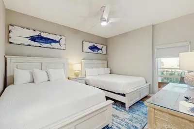 a bedroom with two white beds and a table at Beach dwelling with great view pool & pickleball - snowbird-friendly in Seacrest