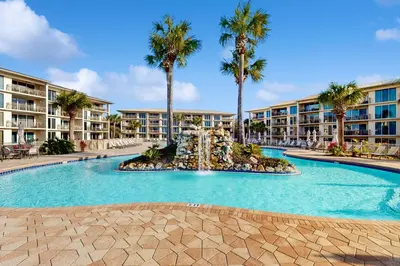 a swimming pool with a fountain in front of a building at Beach dwelling with great view pool & pickleball - snowbird-friendly in Seacrest