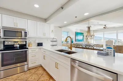 a kitchen with white cabinets and stainless steel appliances at Beach dwelling with great view pool & pickleball - snowbird-friendly in Seacrest