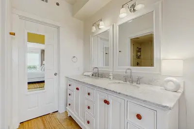 a white bathroom with a sink and a mirror at Condo on the beach with tennis pickleball shuffleboard & balcony in Seacrest