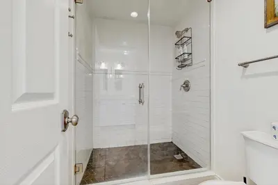 a shower with a glass door in a bathroom at Condo on the beach with tennis pickleball shuffleboard & balcony in Seacrest