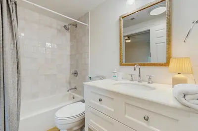 a bathroom with a sink and a toilet and a mirror at Condo on the beach with tennis pickleball shuffleboard & balcony in Seacrest