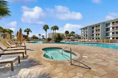a swimming pool with a slide next to a building at Condo on the beach with tennis pickleball shuffleboard & balcony in Seacrest