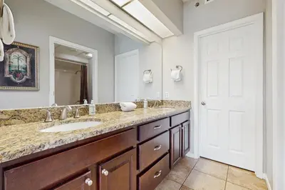 a bathroom with two sinks and a large mirror at Elegant abode overlooking the pool with beach access tennis & pickleball in Seacrest