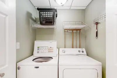 a washer and dryer in a small laundry room at Elegant abode overlooking the pool with beach access tennis & pickleball in Seacrest