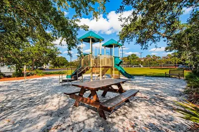 a park with a playground and a picnic table at Gorgeous home with tennis pickleball pool & hot tub - steps from the beach in Seacrest