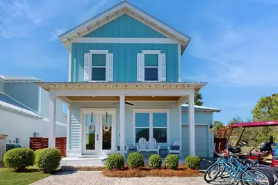 a blue house with bikes parked in front of it at Sleek beach-themed retreat with patio bikes LSV & pool access in Inlet Beach