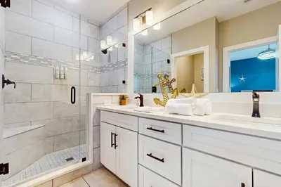 a bathroom with two sinks and a shower at Sleek beach-themed retreat with patio bikes LSV & pool access in Inlet Beach