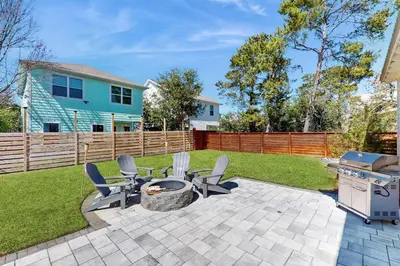 a patio with chairs and a grill in a yard at Sleek beach-themed retreat with patio bikes LSV & pool access in Inlet Beach