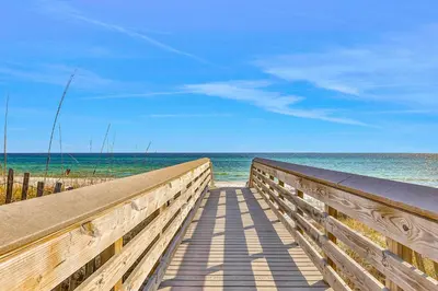 a wooden boardwalk to the beach with the ocean at Sleek beach-themed retreat with patio bikes LSV & pool access in Inlet Beach