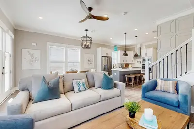 a living room with a white couch and a blue chair at Sleek beach-themed retreat with patio bikes LSV & pool access in Inlet Beach