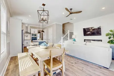 a kitchen and living room with a table and a couch at Sleek beach-themed retreat with patio bikes LSV & pool access in Inlet Beach