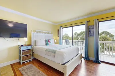 a bedroom with a bed and a balcony at Beachview studio with full kitchen shared pool and beach access in Santa Rosa Beach