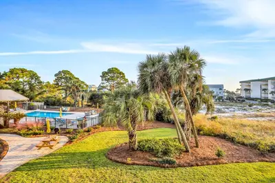 a resort with a pool and palm trees at Beachview studio with full kitchen shared pool and beach access in Santa Rosa Beach