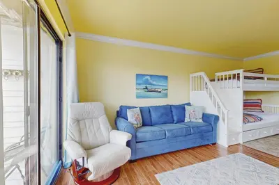 a living room with a blue couch and a bunk bed at Beachview studio with full kitchen shared pool and beach access in Santa Rosa Beach
