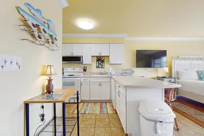 a kitchen with white cabinets and a sink and a toilet at Beachview studio with full kitchen shared pool and beach access in Santa Rosa Beach