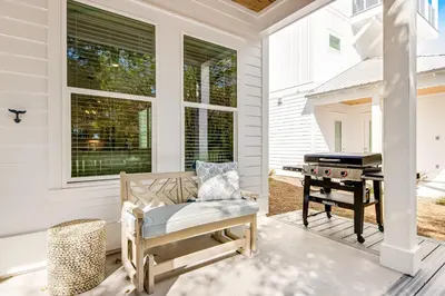 a screened porch with a bench and a grill at Dog-friendly home with community pool flat top grill and custom coffee bar in Rosemary Beach
