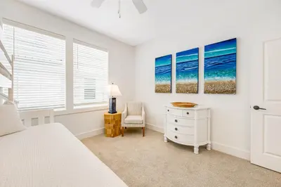 a bedroom with a bed and a desk and a chair at Dog-friendly home with community pool flat top grill and custom coffee bar in Rosemary Beach