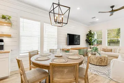 a living room with a table and a couch at Dog-friendly home with community pool flat top grill and custom coffee bar in Rosemary Beach