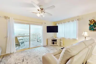 a living room with a couch and a ceiling fan at Dog-friendly beachfront townhouse with balcony 2 bikes W&D in Rosemary Beach