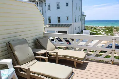 a balcony with two chairs and the ocean at Dog-friendly beachfront townhouse with balcony 2 bikes W&D in Rosemary Beach