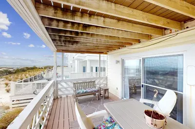 a deck with a table and chairs on a balcony at Dog-friendly beachfront townhouse with balcony 2 bikes W&D in Rosemary Beach