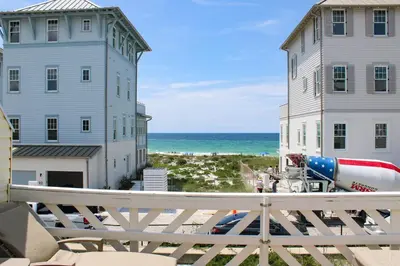 a view of the beach between two buildings at Dog-friendly beachfront townhouse with balcony 2 bikes W&D in Rosemary Beach