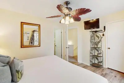 a bedroom with a bed and a ceiling fan at Dog-friendly beachfront townhouse with balcony 2 bikes W&D in Rosemary Beach