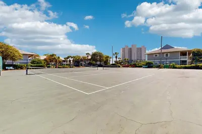 a tennis court with two tennis rackets on it at Cute ground floor condo with shared pool access to shuffleboard and tennis in Santa Rosa Beach