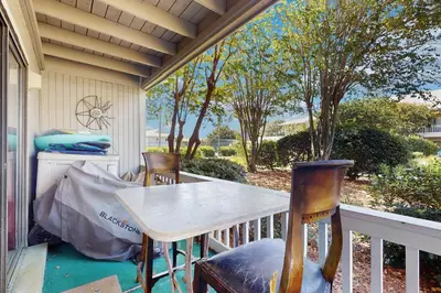 a porch with a table and chairs on a balcony at Cute ground floor condo with shared pool access to shuffleboard and tennis in Santa Rosa Beach