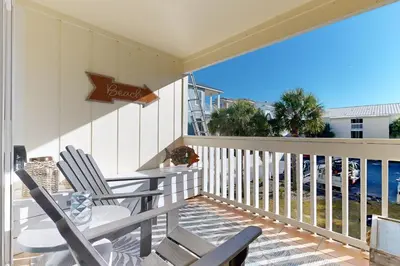 a balcony with a table and chairs and the ocean at Courtyard view condo with private beach access private balcony & free WiFi in Santa Rosa Beach