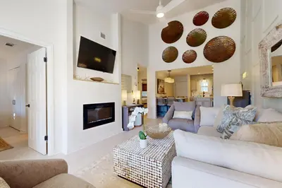 a living room with a couch and a fireplace at Courtyard view condo with private beach access private balcony & free WiFi in Santa Rosa Beach