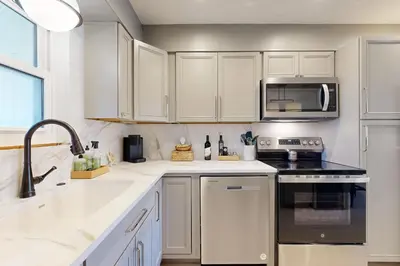 a white kitchen with a sink and a microwave at Courtyard view condo with private beach access private balcony & free WiFi in Santa Rosa Beach