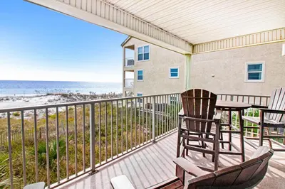 a balcony with a table and chairs and the beach at Oceanfront condo with pool access washer&dryer central AC and ocean view in Santa Rosa Beach