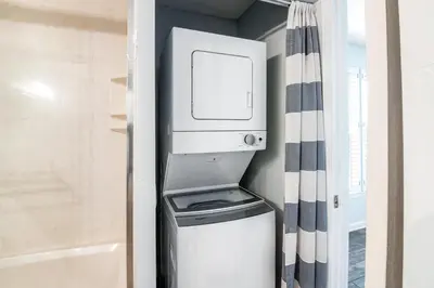 a washer and dryer in a bathroom next to a shower at Oceanfront condo with pool access washer&dryer central AC and ocean view in Santa Rosa Beach