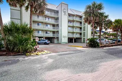 an empty street in front of a building with palm trees at Oceanfront condo with pool access washer&dryer central AC and ocean view in Santa Rosa Beach