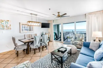 a living room with a blue couch and a table at Oceanfront condo with pool access washer&dryer central AC and ocean view in Santa Rosa Beach