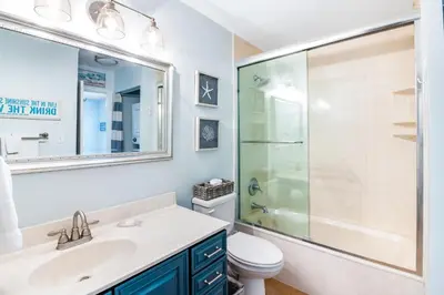 a bathroom with a shower and a sink and a toilet at Oceanfront condo with pool access washer&dryer central AC and ocean view in Santa Rosa Beach