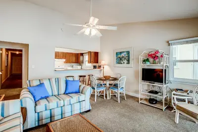 a living room with a couch and a table at Picturesque gulf-front condo on 30A Steps to beach Charcoal grills on-site in Santa Rosa Beach