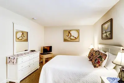 a bedroom with a white bed and a television at Picturesque gulf-front condo on 30A Steps to beach Charcoal grills on-site in Santa Rosa Beach