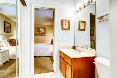 a bathroom with a sink and a mirror and a bed at Picturesque gulf-front condo on 30A Steps to beach Charcoal grills on-site in Santa Rosa Beach