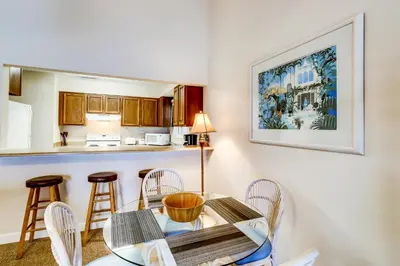 a dining room with a table and chairs and a kitchen at Picturesque gulf-front condo on 30A Steps to beach Charcoal grills on-site in Santa Rosa Beach