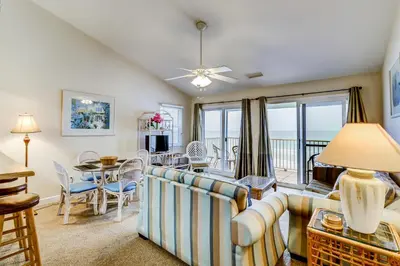 a living room with a couch and a table at Picturesque gulf-front condo on 30A Steps to beach Charcoal grills on-site in Santa Rosa Beach